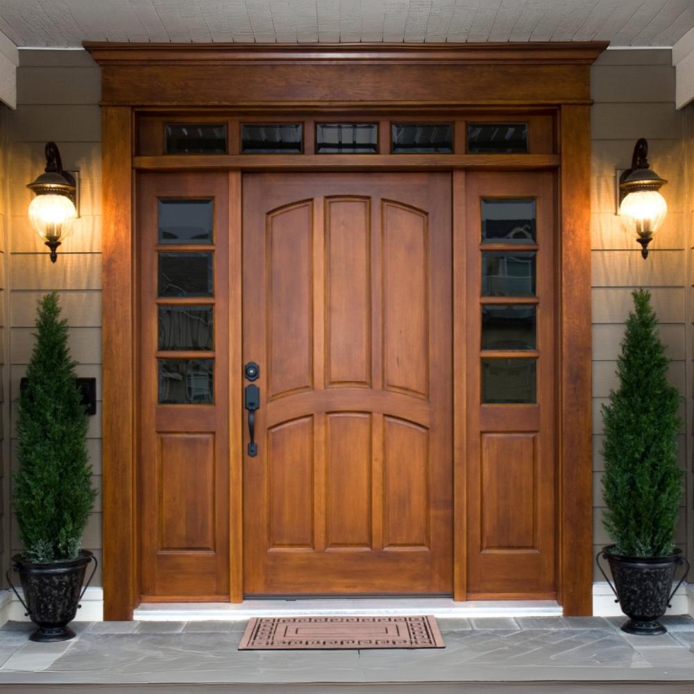 Timber entrance door with sidelights and overhead glazing, lit at dusk